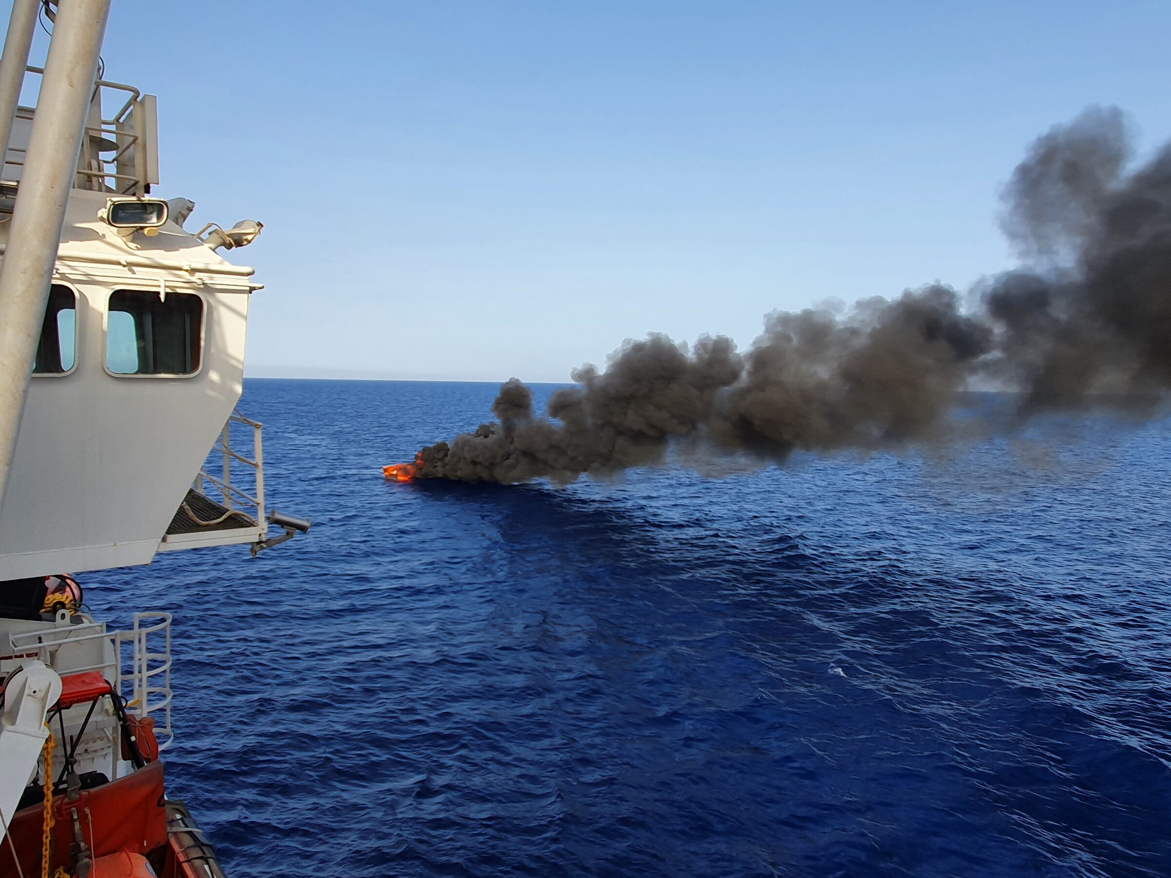 A wooden boat was set on fire at sea, likely by the Libyan Coast Guard