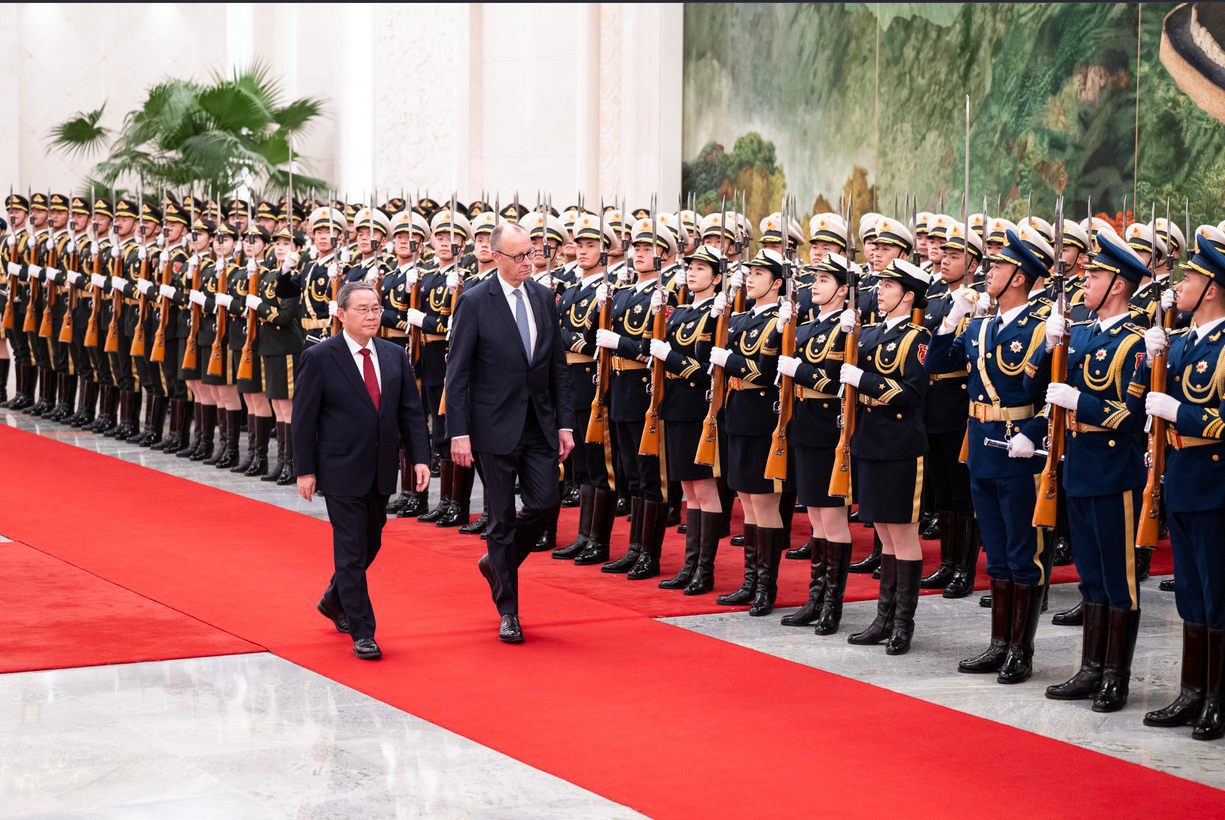 German Chancellor Friedrich Merz and Chinese premier Li Qiang standing alongside each other in the Great Hall of the People