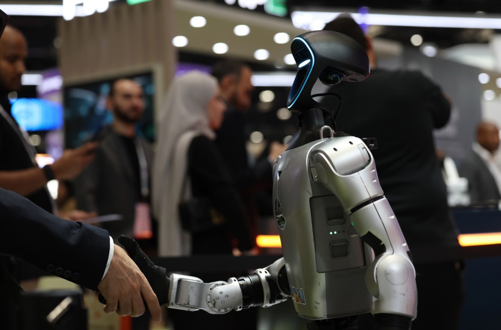 epa13285062 A visitor shakes hands with a robot at the AI Everything Abu Dhabi conference and exhibition in Abu Dhabi, United Arab Emirates, 06 October 2026. The two-day event gathers global tech leaders, innovators, and policymakers to discuss developments in artificial intelligence across the region. EPA/ALI HAIDER